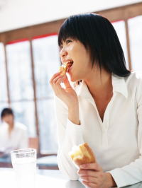 パンを前歯で噛んでいる女性の写真。